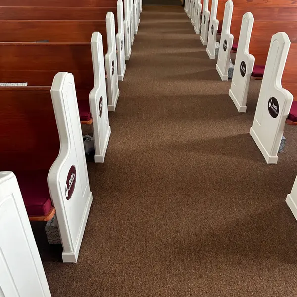 Church sanctuary aisle carpet between white pews after cleaning in Trophy Club