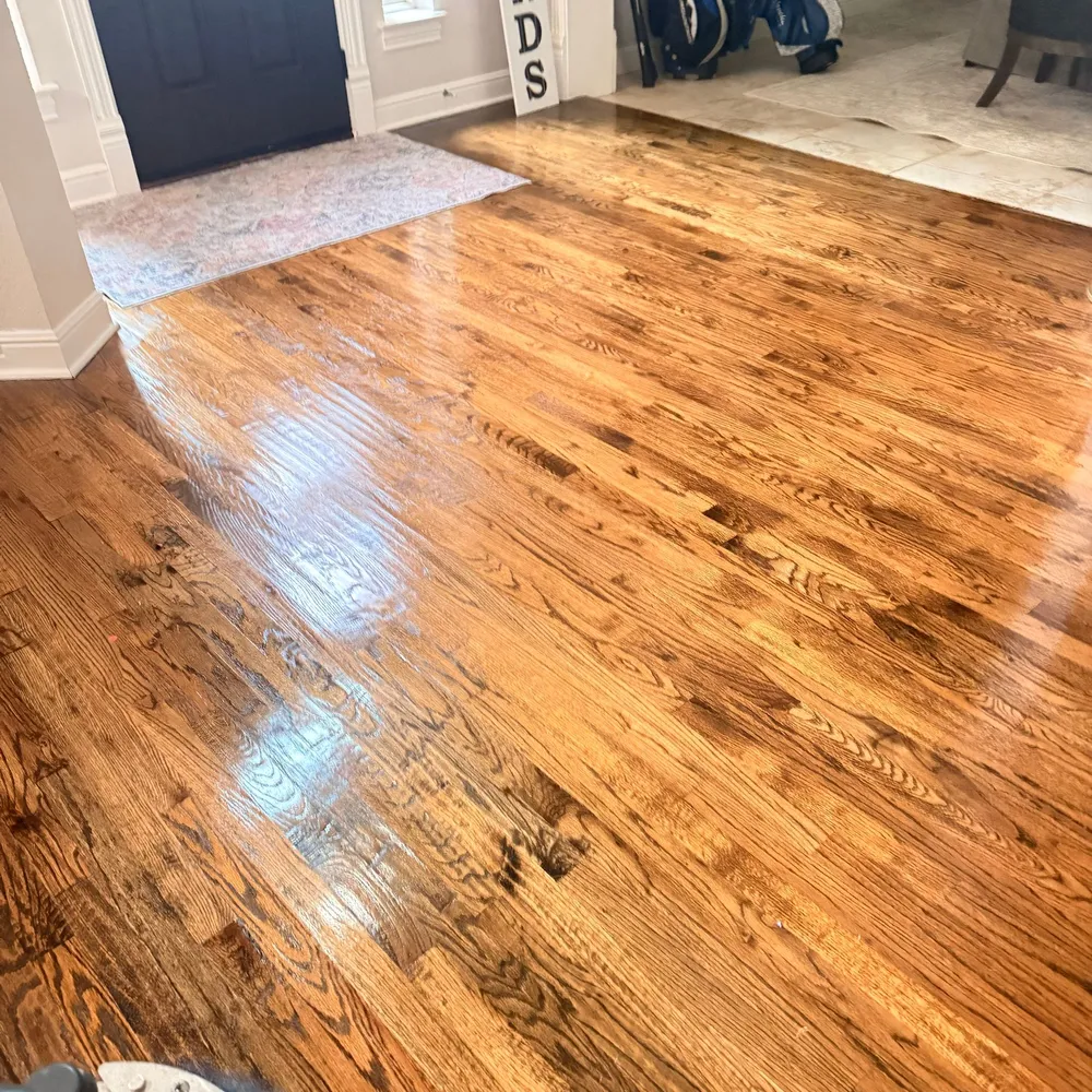 Freshly cleaned and buffed red oak hardwood floor shining in a home entryway