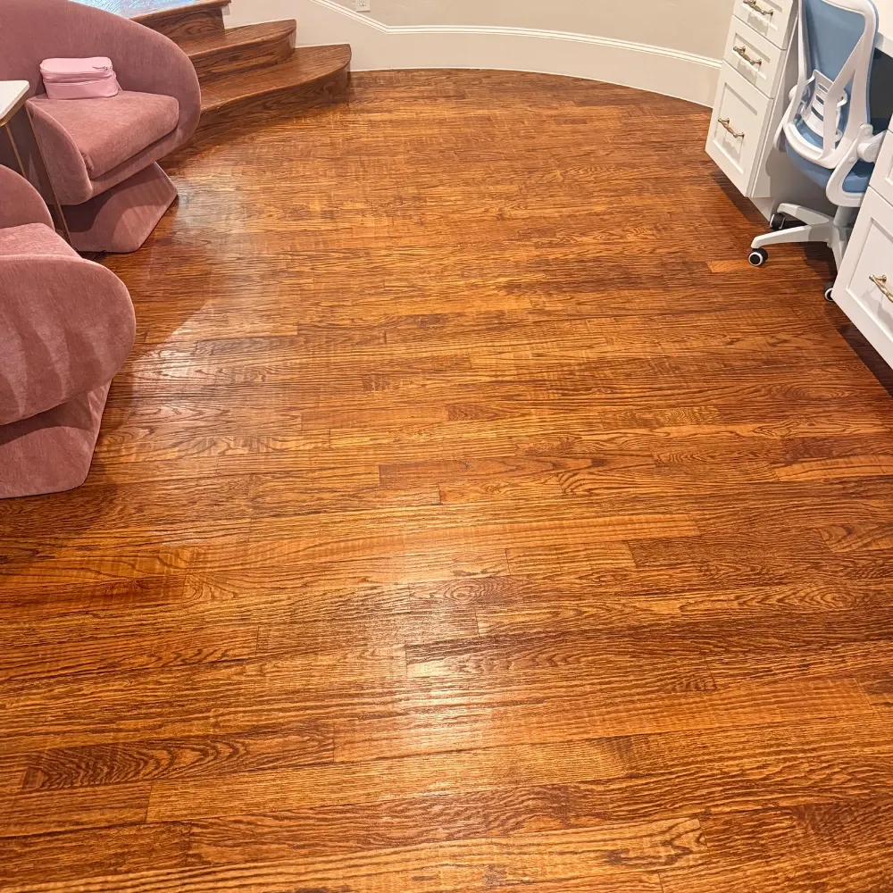 Glossy hardwood floor in a round room after cleaning and buffing
