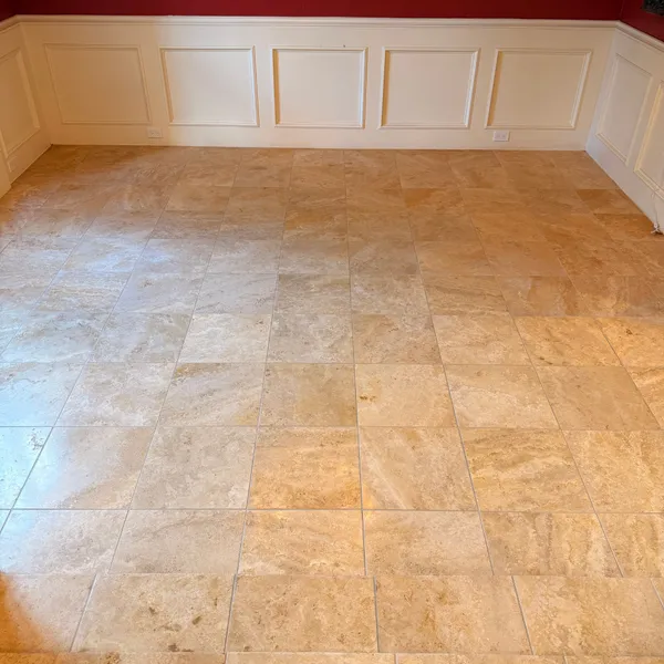 Travertine floor in a dining room with white wainscoting after cleaning