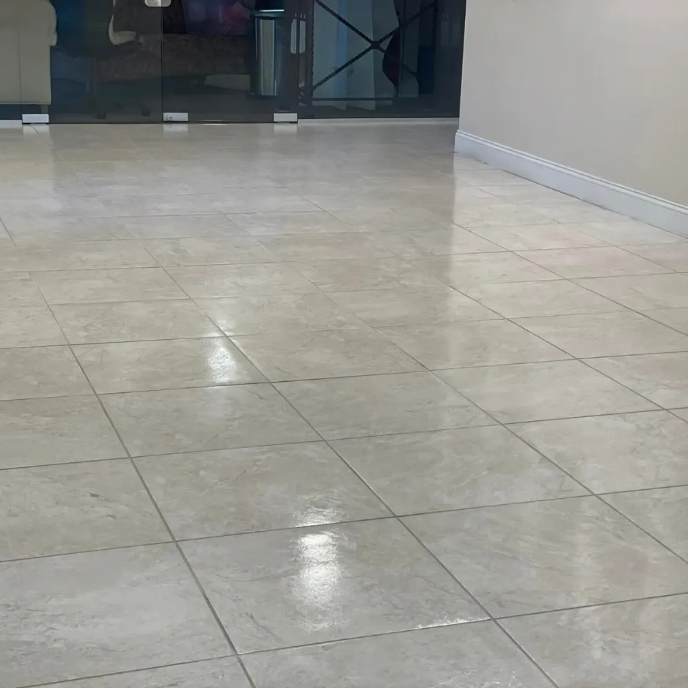 Glossy tile floor by glass doors after tile cleaning