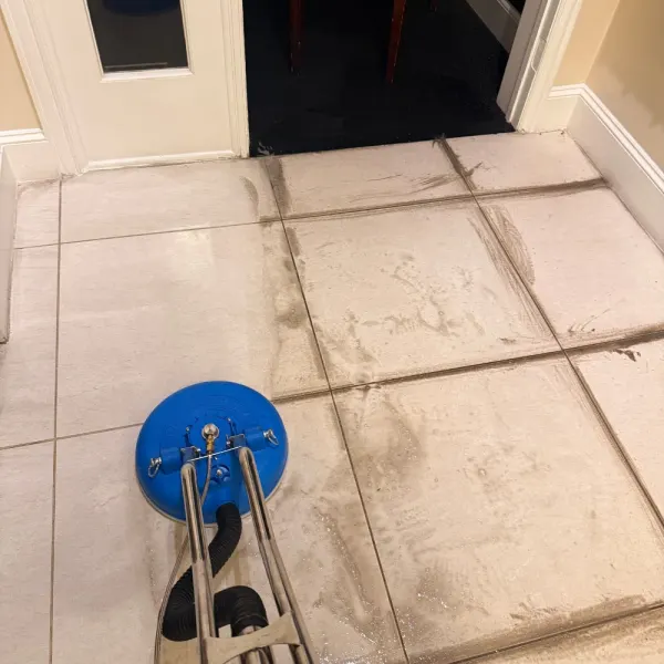 Tile floor partway through cleaning with a spinning surface tool