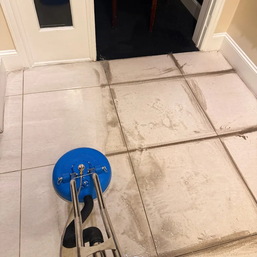 Tile floor partway through cleaning with a spinning surface tool