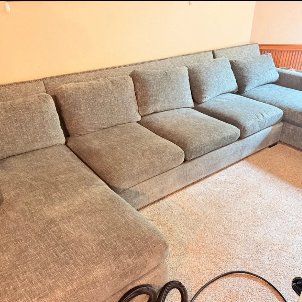 Gray sectional with nailhead trim after upholstery cleaning